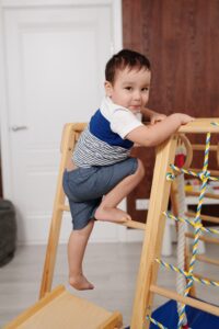 A young child plays on climbing equipment 