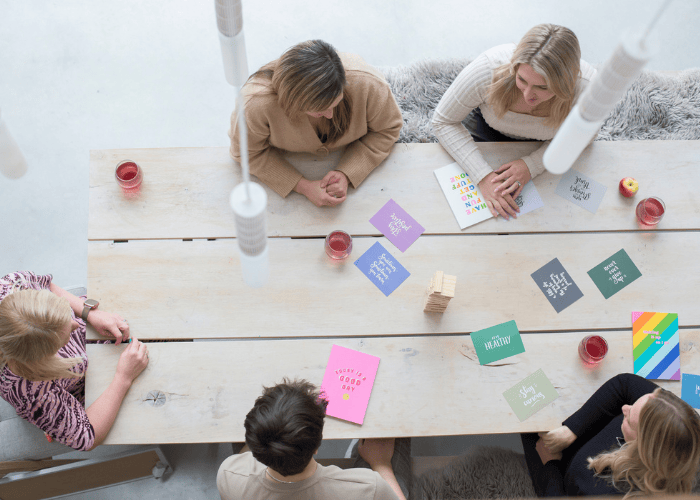 Birds eye shot of team coaching with team members sat around affirmation cards.